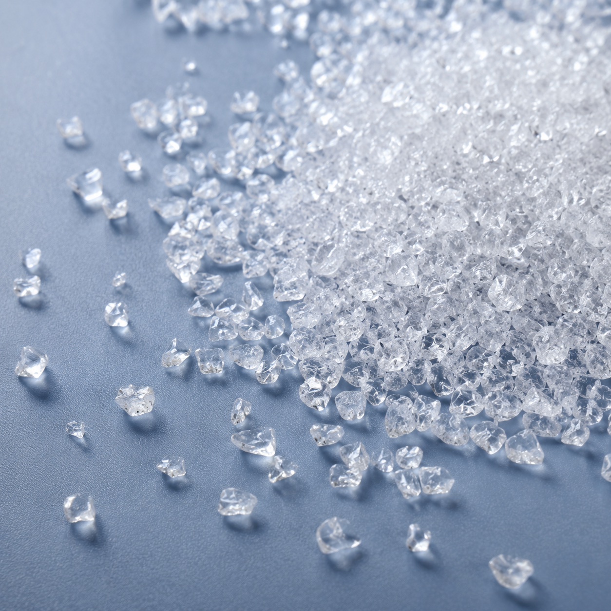 Superabsorbent polymer granules on a blue surface.